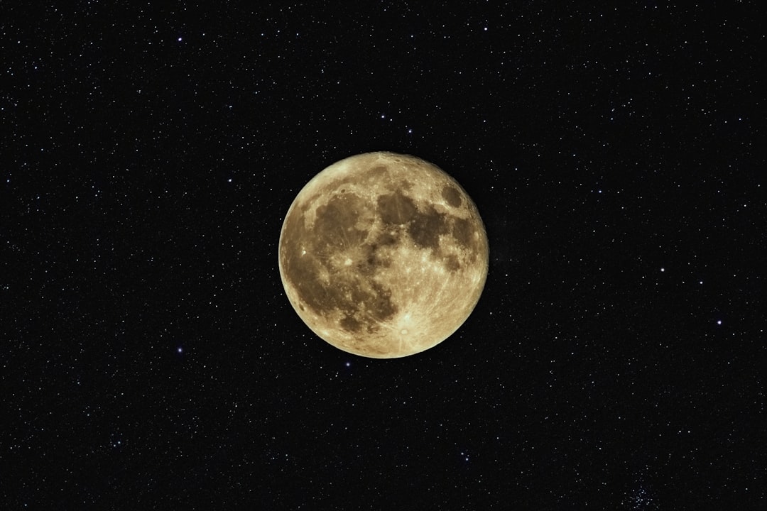 Celestial full moon with craters and shadows against a starry black sky, capturing the beauty of astronomy and the night cosmos with vibrant stars and shadows.